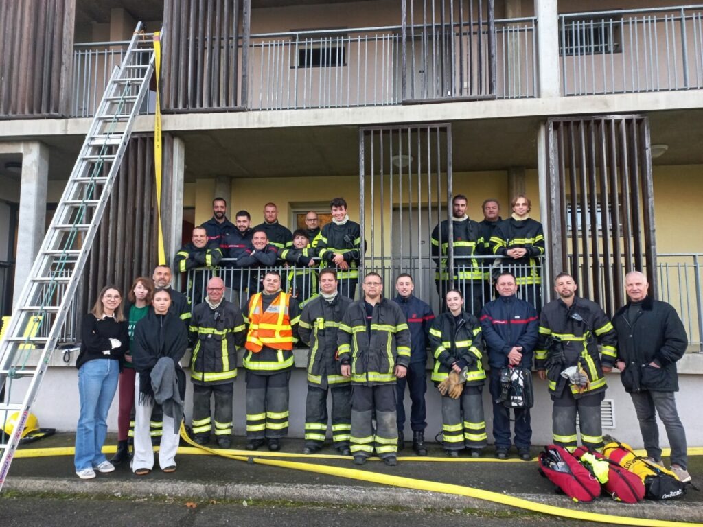 Le groupe de Pompiers devant l'un des bâtiments de DAH a l'issue de l'exercice